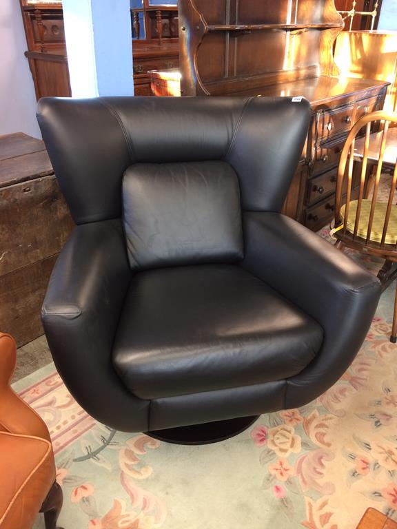 A Parker Knoll black leather swivel armchair