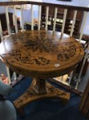 A burr walnut circular centre table with quarter top, supported on a trefoil base and painted with