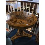 A burr walnut circular centre table with quarter top, supported on a trefoil base and painted with