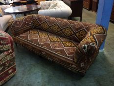 A kilim upholstered Edwardian four seater settee of Chesterfield style, with turned legs and