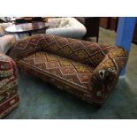 A kilim upholstered Edwardian four seater settee of Chesterfield style, with turned legs and