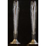 A pair of glass silver based bud vases