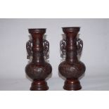 A pair of twin handled Oriental bronzes one handl