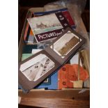 A box of ephemera to include a postcard album