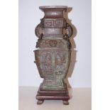 Bronze oriental twin handled vase on wooden plinth