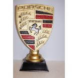 Gold coloured Porsche sign on base