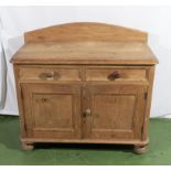 A pine kitchen cabinet with 2 drawers and double doors.