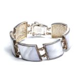 A silver bracelet set with shell