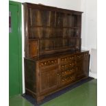 An 18th-century oak cross banded dresser with plate rack with small cupboards, base with end