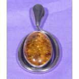 An amber pendant set in a silver mount, total length 6.5cm