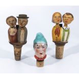 Two hand carved kissing couples bottle stoppers and one other