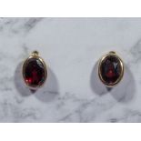 A pair of small 9ct gold and garnet earrings