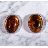 A pair of silver earrings set with amber