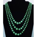 A three strand spinach jade necklace with jade cabouchon clasp, longest strand 52cm