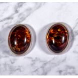 A pair of silver earrings set with amber