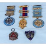 Four silver and enamel badges and a gilt metal Masonic medal