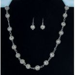 A silver necklace and matching earrings