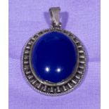 An unmarked silver pendant set with a large blue stone 3.5cm