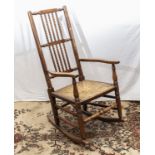 An oak bobbin backed rocking chair with rush seat