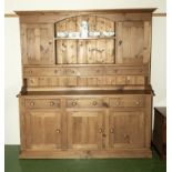 A pine dresser with plate rack/cupboard back