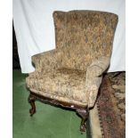 An upholstered winged armchair