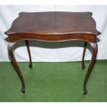 A mahogany table on cabriole legs.