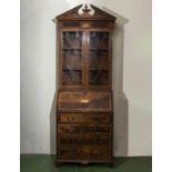 A 20th-century Georgian style inlaid mahogany bureau bookcase.