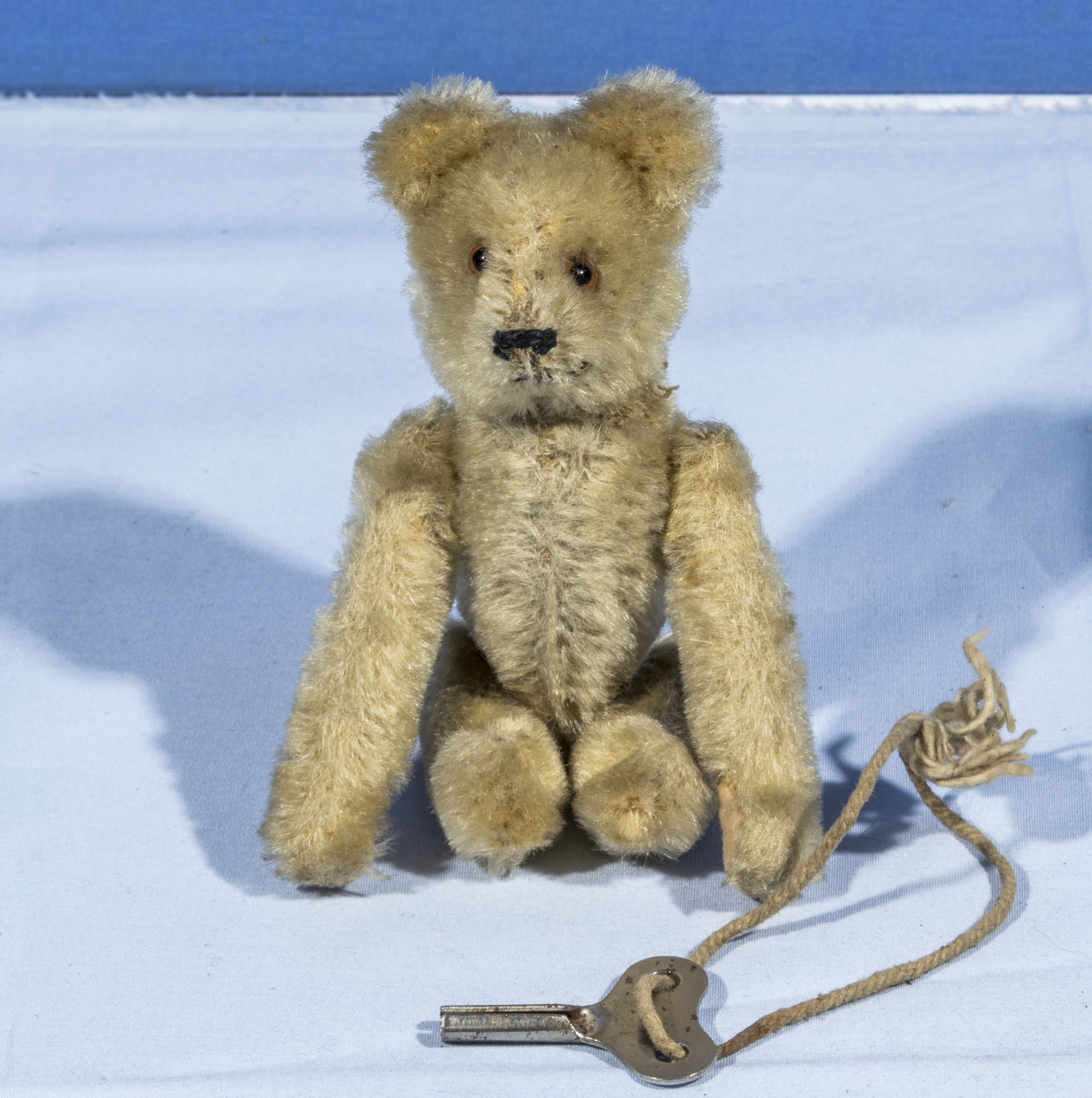 A small vintage mechanical teddy bear with key