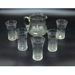 An etched glass pitcher and five glasses