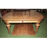 A Mid Victorian golden oak windout dining table with three extra leaves.