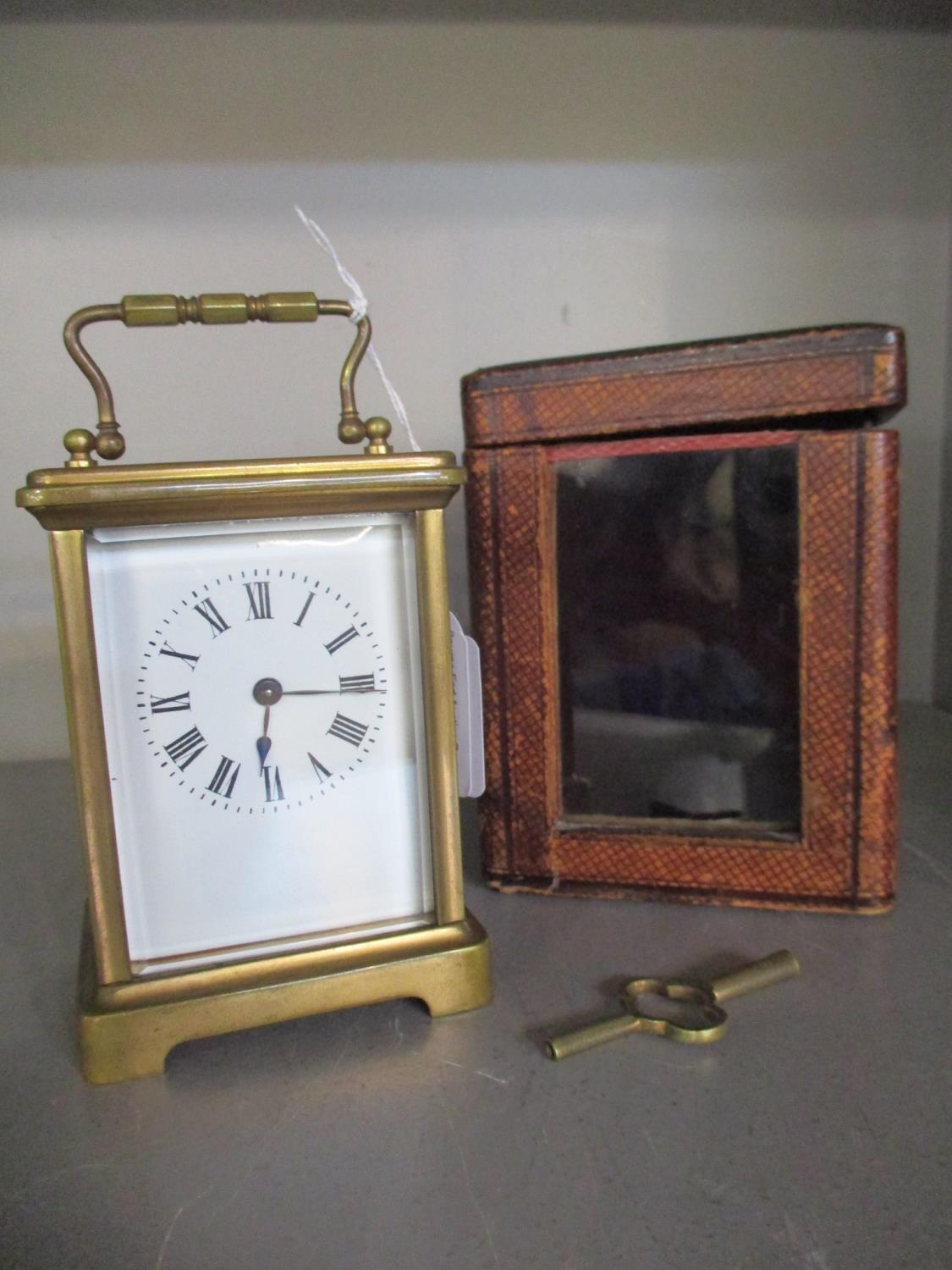 A French brass cased carriage clock, five windows, presentation inscription to top, in leather box