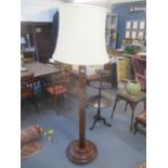 A mahogany finished column turned standard lamp with a cream shade 184cm high