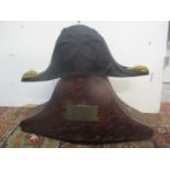 A 19th century Naval bicorn hat, with gilt braid, in a painted metal carrying case, the brass plaque