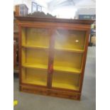 A late 20th century sycamore hanging display cabinet with a pair of glazed doors, over a pair of