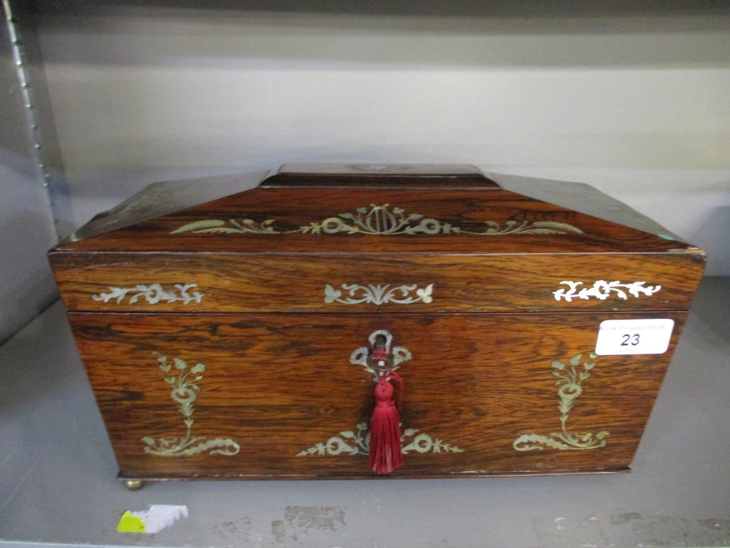 A Regency rosewood and floral mother of pearl inlaid sarcophagus tea caddy, the fitted interior with