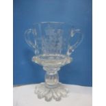 A George V and Queen Mary commemorative, twin handled glass cup with a faceted hollow stem