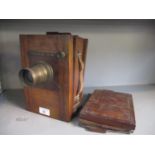 An early 20th century wooden plate camera with brass Lancaster & Sons plate camera lens, with plates