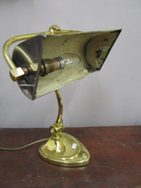 An Art Nouveau brass desk lamp with brass and silver plated shade, adjustable curved column on heart