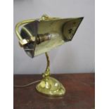 An Art Nouveau brass desk lamp with brass and silver plated shade, adjustable curved column on heart