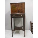 An Edwardian string inlaid mahogany smokers cabinet with a hinged gallery top, enclosing a