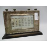 A mid 20th century silver desk calendar A/F