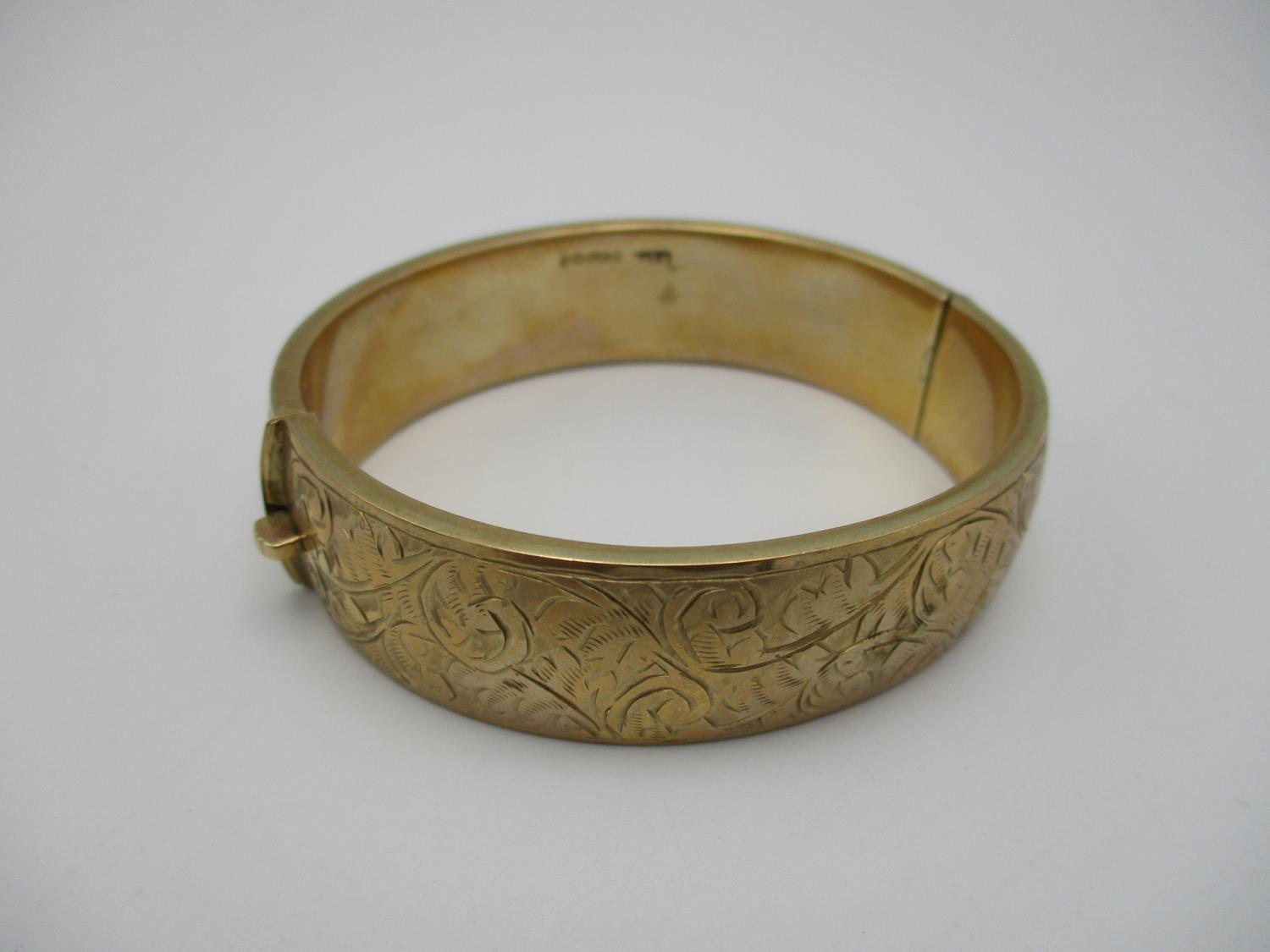 A 9ct gold engraved bangle, designed with etched scrolls of foliage throughout the exterior, 5.8 - Image 2 of 4