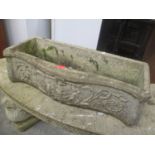 A garden stoneware trough planter having a serpentine front and floral decoration 21.5 h x 74cm w