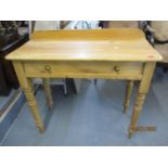 A Victorian pine side table with raised back having one long drawer above ring turned legs