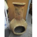 A garden terracotta chimenea having grape vine decoration 93cm h