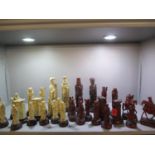 A quantity of thirty two Oriental inspired resin chess pieces in red and ivory colours