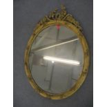 A late 19th century gilt gesso oval mirror surmounted by flora and ribbons