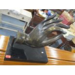 Object d'Art - a mounted bronze hand above a black composition base 44 x 44cm