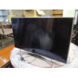 An LG 43" flat-screen tv on stand with remote