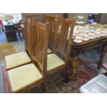 An oak draw leaf table standing on fluted columns and a set of four oak framed dining chairs